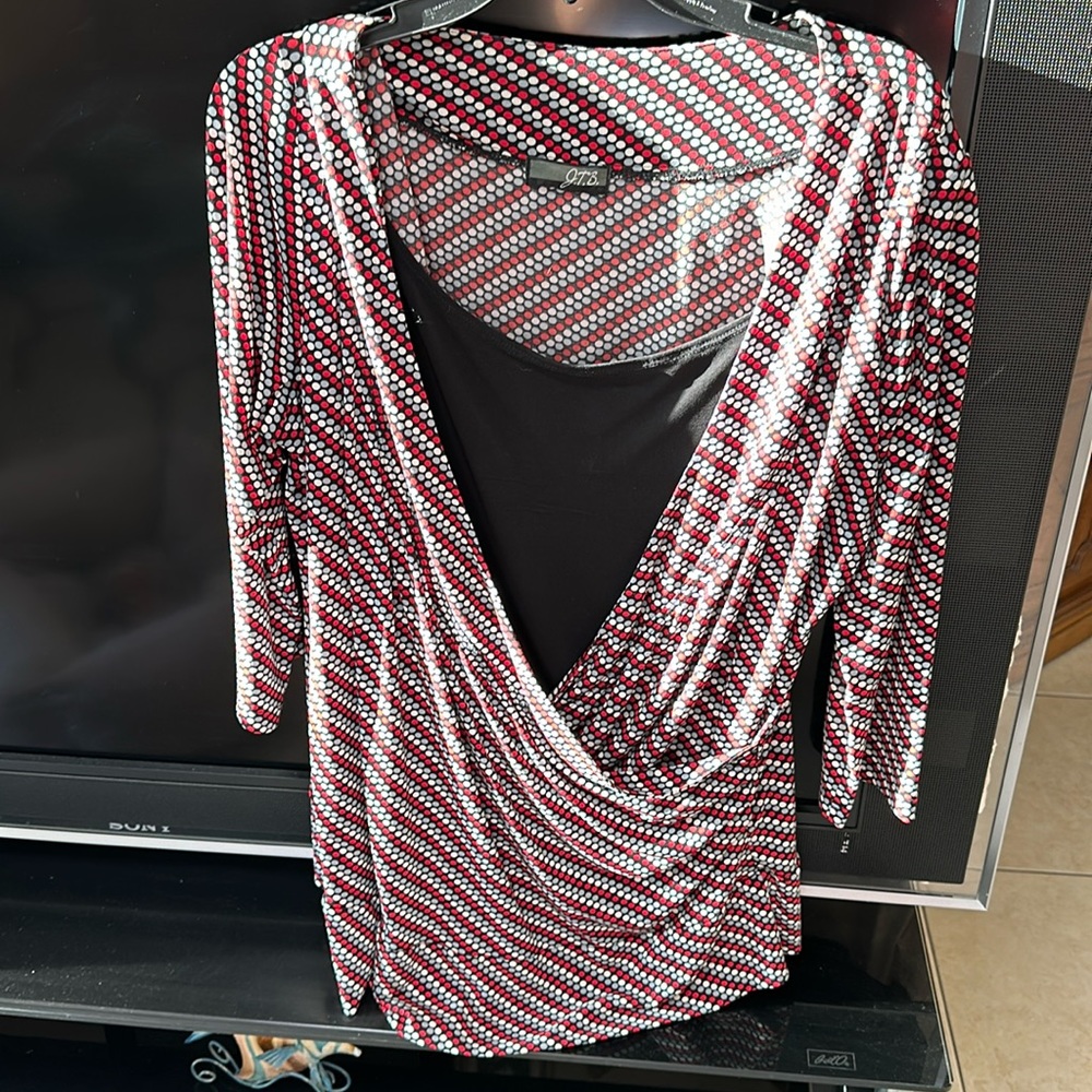 Red, gray, white and black gathers at the waist and has 3/4 length sleeves.
